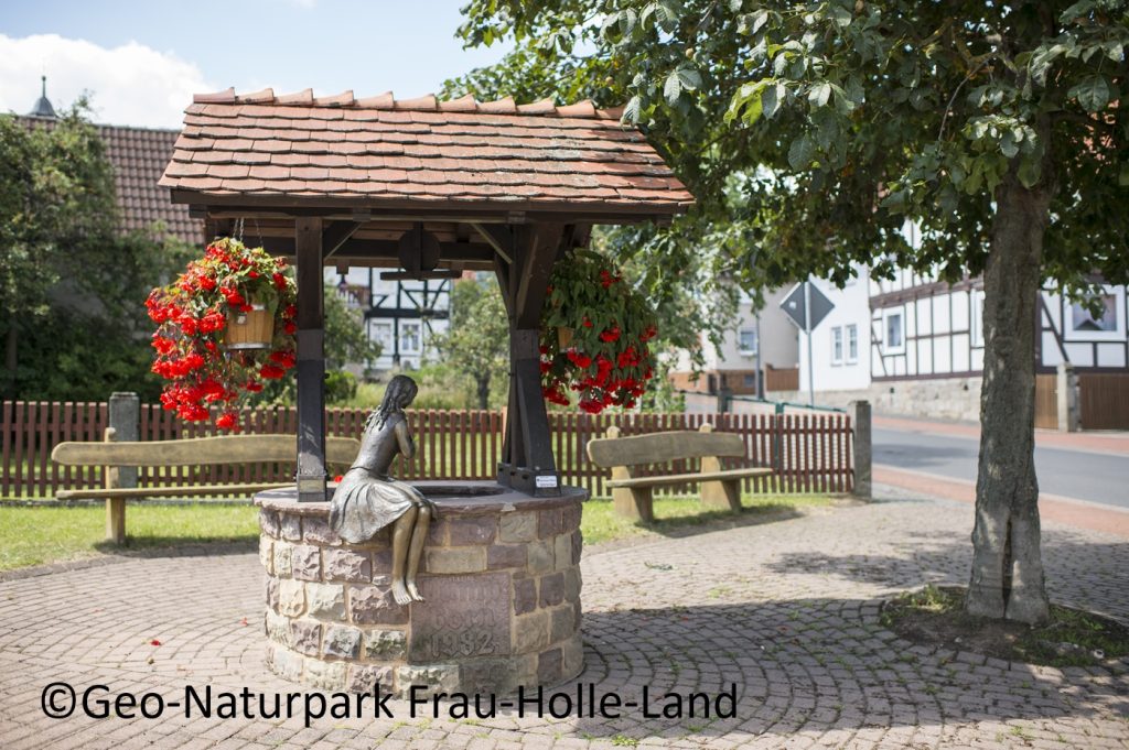 Foto eines Brunnens auf einem Dorfplatz